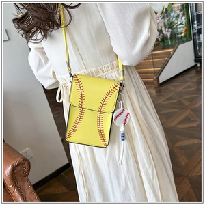 Detailed view of yellow baseball crossbody bag with red stitching on a white dress