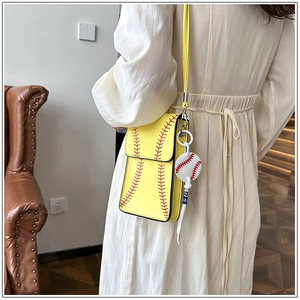 Detail shot of yellow baseball-themed crossbody bag with red stitching and ball charm
