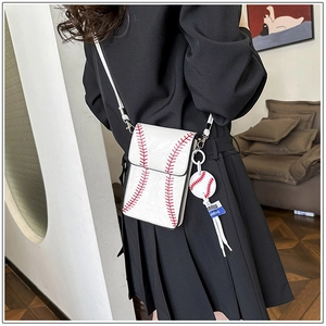 Detail of white leather baseball crossbody bag with red stitching and matching charm