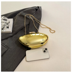 Close-up of golden shell evening bag with mirror finish and delicate chain strap
