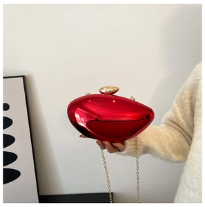 Detail of red metallic evening bag with high-gloss finish and gold clasp closure