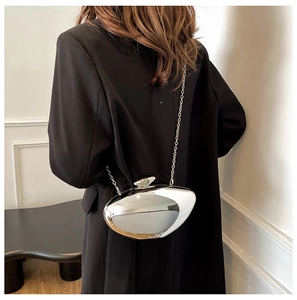Detail view of mirror finish acrylic clutch bag with a metallic silver crossbody chain