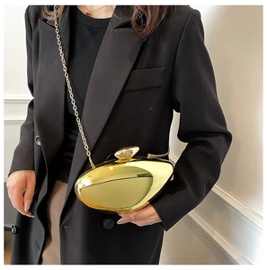 Close-up of polished gold metallic mango bag with chain strap and pebble twist lock