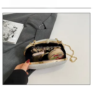 Silver glitter evening box bag interior view showing capacity for phone and makeup items