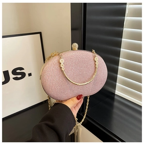 Detailed close-up of pink glitter evening bag with gold metal trim and diamond clasp