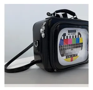 Dettaglio della borsa a forma di TV vintage con zip a cuore e schermo No Signal a colori