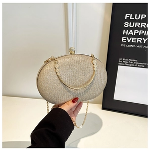Detail of glittery champagne gold evening clutch bag with crystal clasp and chain strap