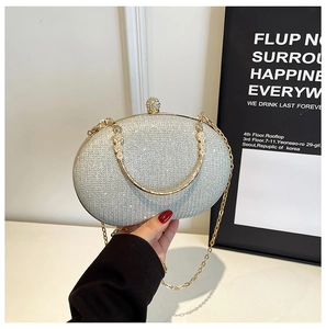 Macro shot of sparkling silver glitter evening clutch with golden metal frame and chain