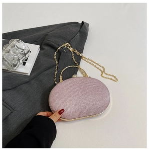 Detail of pink sequin clutch bag with gold handle and chain on aesthetic background
