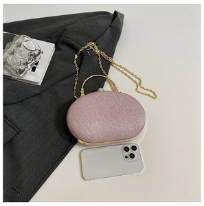 Pink sequin evening bag with gold handle and chain shown next to a smartphone for scale
