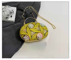 Detail showing vintage yellow sequin floral embroidery and gold metal handle on bag