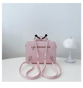 Dettaglio dello zaino rosa chiaro con zip a cuore e fiocco nero in stile romantico