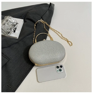 Detail of silver glitter evening clutch bag with gold handle and metal chain