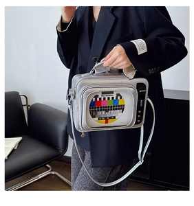 Dettaglio della borsa argento a forma di TV vintage con schermo No Signal