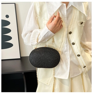 Detail of black sequin evening clutch bag with gold floral handle and crystal clasp
