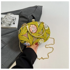 Detailed view of green Chinese style evening bag with floral embroidery and sequins