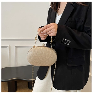 Detail of champagne gold glitter clutch bag with pearl clasp and metal handle