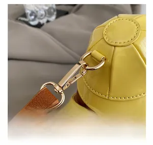 Detail shot of bright yellow patent leather bag with premium gold metal hooks and zippers