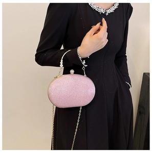 Pink sequin evening clutch bag with pearl handle and golden chain detail view