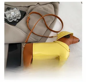 Detailed view of dachshund-shaped crossbody bag on grey blazer with yellow accents