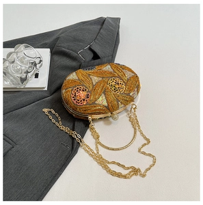 Detail of gold sequin floral evening bag with pearl clasp and metal ring handle