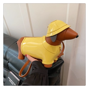 Detail of creative dachshund shoulder bag with yellow glossy finish and cute sun hat