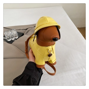 Macro detail of dachshund-shaped crossbody bag featuring yellow raincoat and brown leather