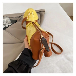Detailed view of dachshund dog shaped crossbody bag with brown leather and yellow patent finish