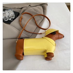 Close-up of creative dachshund dog shoulder bag with yellow raincoat and gold hardware