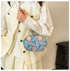 Detail of evening bag with hand-sewn floral sequins, gold handle and detachable chain