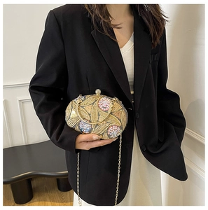 Detail of evening bag with gold floral embroidery, sequins and rhinestone clasp