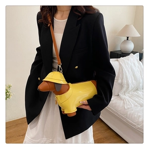 Detail of creative dachshund-shaped shoulder bag in yellow with brown leather accents