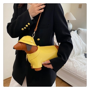 Detail of creative dachshund dog-shaped crossbody bag with yellow sun hat and metal buckle