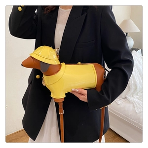 Detail of creative dachshund crossbody bag in yellow and brown with adjustable strap