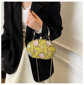 Detail of yellow-green evening bag with intricate leaf sequins and floral beadwork