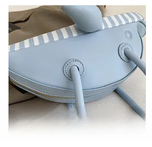 Detail showing precise stitching and striped edge on a blue dolphin-shaped handbag