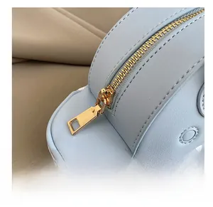 Detailed macro view of light blue leather texture with smooth gold zipper and stitching