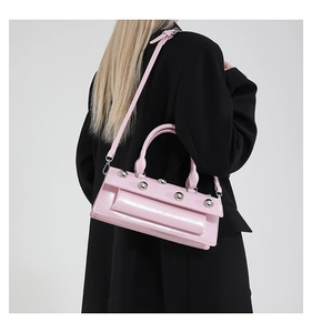 Détail de la texture cuir verni rose et des rivets argentés sur le sac à main élégant