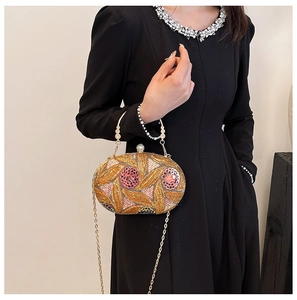 Close-up of sparkling sequin晚宴 bag with pearl flower detail and gold ring handle
