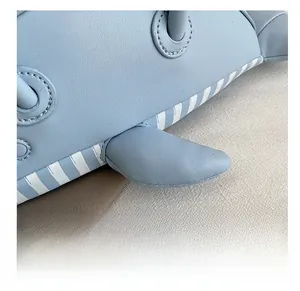Detail of light blue dolphin bag with faux leather texture and striped webbing strap
