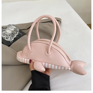 Detail of pink dolphin-shaped handbag with round soft handles and striped bottom design