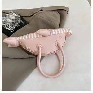 Detailed view of pink fish-shaped handbag with 3D fins and smooth PU leather finish