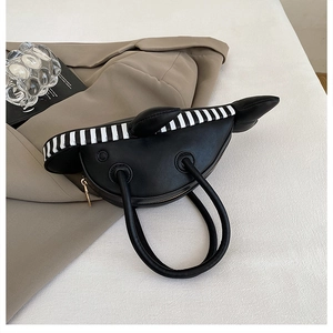 Detail of creative dolphin-shaped shoulder bag with black PU leather and gold zipper