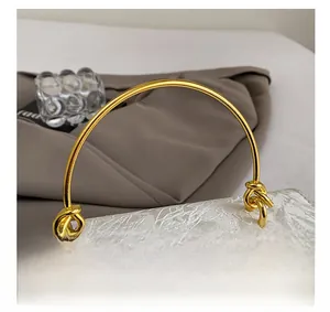 Close-up of beige jacquard floral fabric and gold circular handle on a stylish handbag