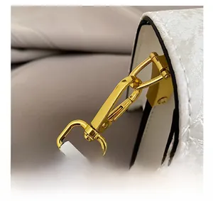 Close-up of premium gold metal clasp on white floral jacquard small crossbody bag