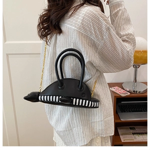 Detail showing dolphin-shaped bag with black leather and white striped pattern