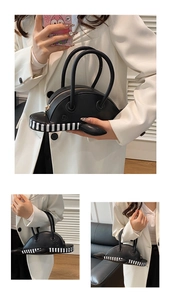 Detail of whale-shaped handbag with black leather texture and striped ribbon accents