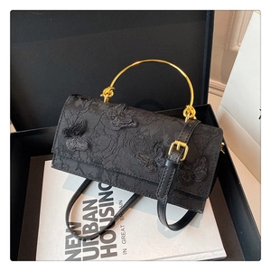Vue détaillée du sac en dentelle noire avec appliques papillons dans un coffret cadeau