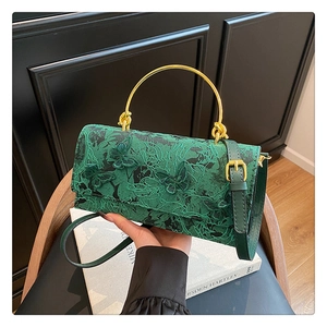 Détail du sac en dentelle vert forêt avec papillons 3D et poignée en métal doré