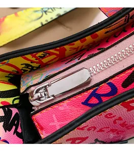 Macro shot of silver metal zipper and graffiti pattern on cross-grain faux leather bag